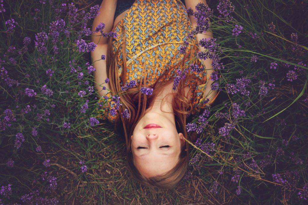 Donna sdraiata tra fiori viola