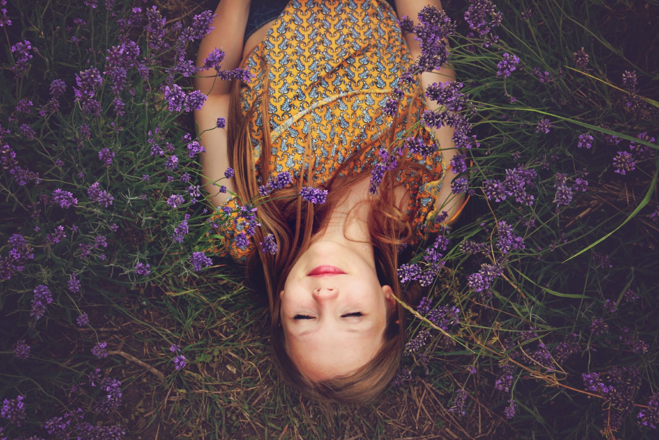 Donna sdraiata tra fiori viola